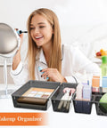 Woman using makeup with 25 Piece Plastic Drawer Organizer Set With 4 Size Versatile Trays And Storage Bins For Makeup Jewelry Gadgets In Bathroom Bedroom And Office Clear Black in foreground.
