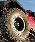 Red 4x4 vehicle on rugged terrain with visible off-road tires, showcasing installation of a Beefy Manual Locking Hub With 19 Splines And 1 Pair For OEM Replacement