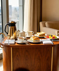 Breakfast setup on a wooden cart with tea set and food in a modern room