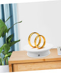 Autonomic Electric Rotating Display Stand For Jewelry Watches And Collectibles With Adjustable Speed, showcasing two gold rings on white turntable.
