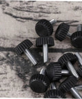 Twenty Adjustable Furniture Leveling Cups With Threaded Socket Design, black plastic and metal bolts on a textured surface.
