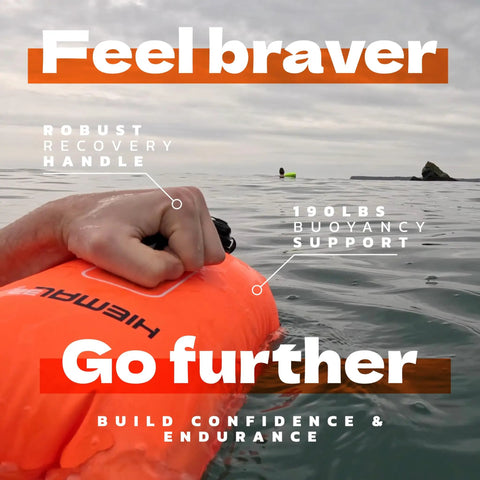 Hand gripping Open Water Swim Buoy With 15L Dry Bag and Rest Handle, Fully Waterproof Swim Bubble in Furnace Orange on water surface.