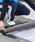 Person installing Top Shelf Self Adhesive Roofing Felt Repair Tape, 3.3 x 32.8 ft, on a flat surface for leak sealing.