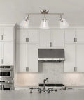 Vintage Inspired Dope Brushed Nickel Three Light Track Lighting With Pivoting Heads And Clear Glass Shades For Industrial Farmhouse Coastal Spaces Bulb Not Included mounted above a modern kitchen