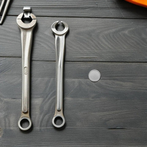 10 Pack Stainless Steel Round Knockout Seal Caps For Electrical Breaker Panels With Heavy Duty Weatherproof Junction Box Plugs and wrenches on a wooden surface.