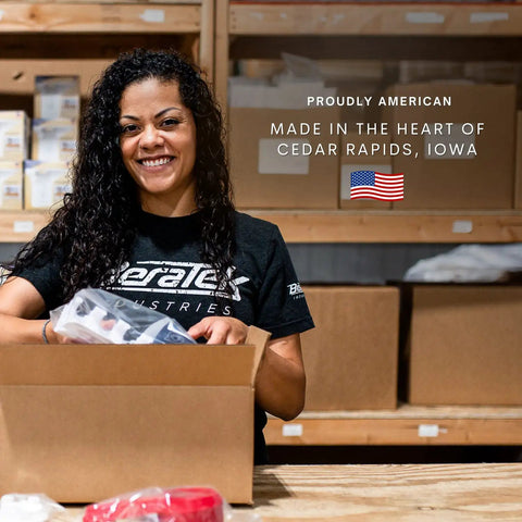 Person packing a box in a warehouse with 'Made in the Heart of Cedar Rapids, Iowa' and an American flag in the background.