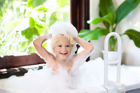 Adjustable Bathtub Safety Rail Grab Bar For Shower With Secure Padded Clamp Stainless Steel White Mobility Aid next to child in bath