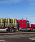 A red truck with a flatbed secured by Beefy Heavy Duty Tie Down Straps 4 In By 30 Ft With Flat Hooks 18,000 Lbs Break Strength WLL 6,000 Lbs 10 Pack
