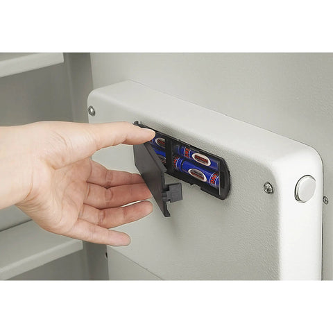 Person accessing battery compartment of in wall safe for home or biz with LED keypad and two manual override keys big interior