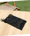 Folded black fabric of Trampoline Sun Shade Canopy Cover For Outdoor Backyards And Parks UV Protection Weather Resistant Top Replacement Easy Fold Trampoline Cover Keeps Kids Cool Safe Play Area Accessories on a wooden table