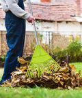 Person using Lightweight Plastic Leaf Rake With 56 Inch Stainless Steel Handle And 22 Tines Plastic Head to gather leaves