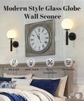 Set of 2 Dope Black Globe Wall Sconces with Milk Glass Shades above bed in bedroom with modern decor.