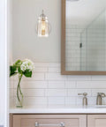 Kira Home Rayne 10" Modern Farmhouse Wall Sconce for Bathroom Vanity, Pack of 2, featuring clear glass shade in sleek bathroom setting.