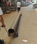 Heavy Duty Pipe Dolly Two Piece Roller Cart For Steel And Fire Pipes With 2200 Pound Capacity hauling a steel pipe down a street.