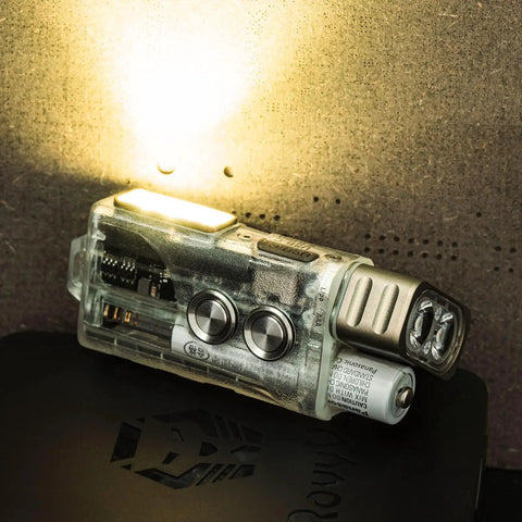 Rechargeable EDC Flashlight With USB C 700 Lumen Dope Keychain Light emitting beam, batteries visible on dark surface