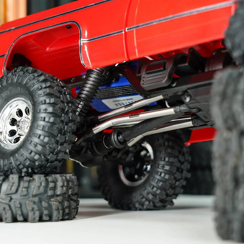 Beefed Up Steel High Clearance Chassis Links For TRX4M High Trail K10 F150 RC Crawler with red body on rocky terrain
