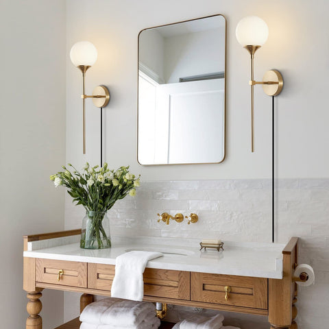 Bathroom scene with Gold Glass Globe Wall Sconces Set Of 2 Plug In Mid Century Modern Look flanking a mirror over a wooden vanity