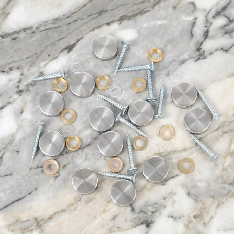 Heavy Duty Mirror Screw Caps With Stainless Steel Decorative Hardware Slick Silver Covers And Copper Silicone Washers Top Shelf Furniture And Glass Sign Fittings Built Like A Tank on marble background.