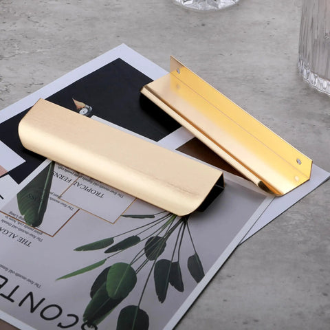 Six Inch Dark Gold Finger Pulls For Kitchen Cabinets And Drawers Aluminum Alloy handles displayed on a magazine.