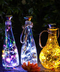 Solar Diamond Wine Bottle Lights 10 Pack with 20 LEDs Outdoor Waterproof Multicolor Fairy String Lights glowing in bottles.