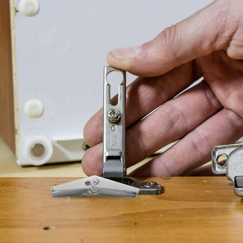 Hand using Galvanized Steel Drywall Toggle Anchors Kit For Heavy Duty Wall Fixings And DIY Installation Toggle Wing Nut Fasteners