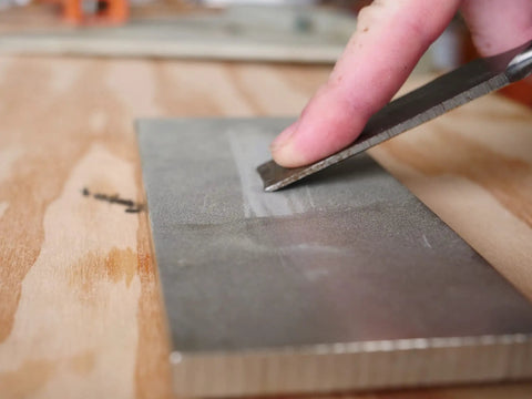 8 Inch Diamond Dia Sharp Whetstone Bench Stone With Medium Extra Fine Grit Sharpener in use, sharpening a knife blade.