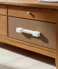 White silicone corner guard attached to wooden drawer handle, part of 8 Pack Silicone Corner Guards For Safety And Soft Edge Protection