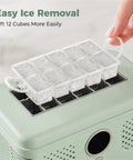 Sleek Countertop Ice Maker With Zero Sweat One Touch Operation And Smooth Self Cleaning Design Blazing Fast Cube Production For Weekend Hangouts Home Bars Or Office Chill Areas Ultra Compact, showing easy ice removal with a tray holding 12 ice cubes.