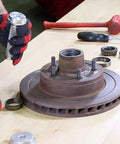 OEMTOOLS bearing race and seal driver set components on workbench with a rusty hub and two bearings