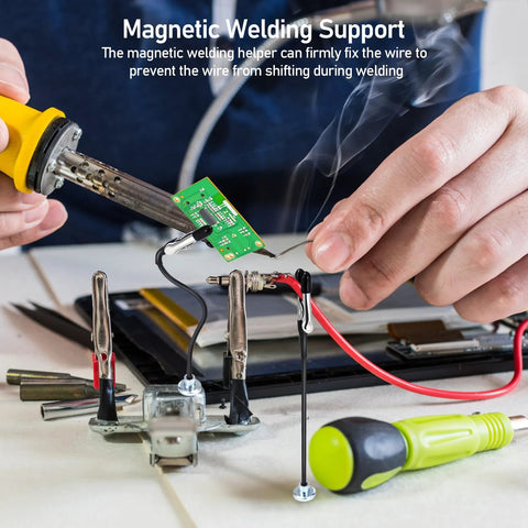 Four magnetic helping hands soldering clamps holding a green PCB and wires during repair