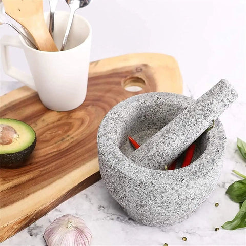 Large Granite Mortar And Pestle Set With 2 Cup Capacity Lid Silicone Lid Garlic Peeler And Anti Slip Base Pad Unpolished Granite Spice Grinder For Grinding Herbs And Spices Kitchen Must Have with chili peppers inside on a kitchen counter.