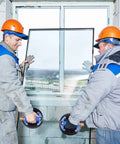 Workers using Beefy 10 Inch Metal Vacuum Suction Cups with Metal Handles for moving glass panels safely in construction site.