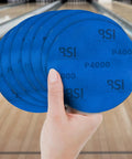 Person holding blue 1000 Grit Bowling Ball Sanding Disc Kit for Resurfacing Machines Ball Spinner and Hand Cleaning Pro Grade Pad