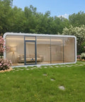 Top Tier Prefab Backyard Office Pod And Soundproof Outdoor Studio Shed Featuring Prime Modular Mobile Design view with glass walls, green lawn, and flowers.