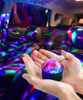 Sound Activated Mini Disco Ball Lights For Cars And Rooms RGB Multicolor DJ Party Lights that sync to your music beat at 60dB, creating a vibrant car interior with strobe effects in the palm of a hand showing an energized colorful atmosphere.