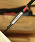 Close-up of a metal magnetic bit holder with a red and black Torx T25 bit inserted