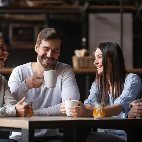 Friends enjoying coffee with 8 Pack 4 Oz Glass Creamer Pitchers Set Clear Milk Pourers on table