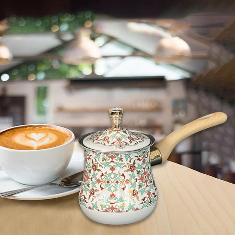 Stainless Steel Turkish Coffee Pot And Milk Warmer With Long Wooden Handle, Red Pattern, 550ml, next to coffee cup in kitchen setting.
