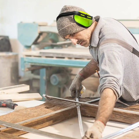 Man wearing earmuffs in workshop, not "Six Piece Kids Noise Reduction Earmuffs And Hearing Protection Headphones Adjustable Padded Defender For School Trips And Playtime Green Color Safe Comfortable Fit For Young Listeners"