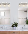 Three Light Brushed Nickel Bathroom Vanity Light Fixture With Clear Glass Shade Over Mirror in a modern bathroom setting