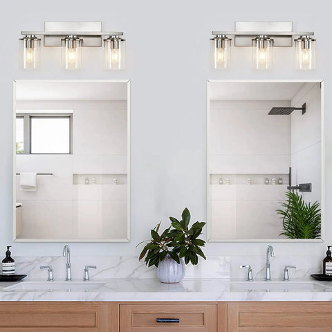 Three Light Brushed Nickel Bathroom Vanity Light Fixture With Clear Glass Shade Over Mirror in a modern bathroom setting