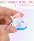 Heart Shaped Magnetic Nail Stand Set For Press Ons, acrylic nail on heart-shaped base with tweezers in use.