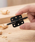 Hand holding a black hinge from the Vintage Iron Jewelry Box Hinges Set 10 Pieces With Heavy Duty Support And Easy Installation