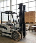 Heavy Duty Side Loading Electric Forklift With 5000 Lb Capacity And Quick Charge Lithium Ion Battery lifting wooden pallet in warehouse.