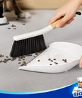 Portable Dustpan and Brush Set With Bamboo Handle in White for quick cleanups, shown sweeping debris into dustpan.