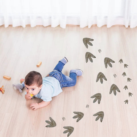 Child playing on floor with 64 Piece Dinosaur Footprint Floor Decals Peel And Stick Dinosaurs Wall Tracks Stickers for Baby Nursery Bedroom