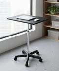 Straight Up Solid Adjustable Rolling Laptop Desk With Heavy Duty Steel Base Mobile Standing Work Table on wheels next to a window.