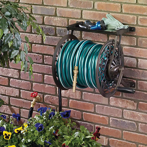 NeverLeak Decorative Wall Mount Hose Reel in brown holding 125 ft of 5/8 inch hose on a brick wall with plants