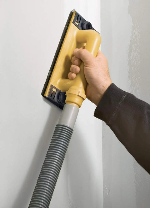 Hand using Dust Free Drywall Vacuum Hand Sander with six foot hose on wall, Easy Clamp system visible