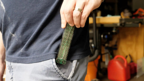 Person placing Dia Fold Handy Portable Pocket Diamond Sharpener Double Sided into jeans pocket, demonstrating portability.